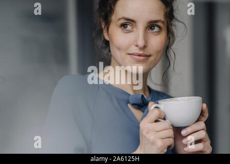 Portrait of young woman relaxing with cup of coffee Stock Photo