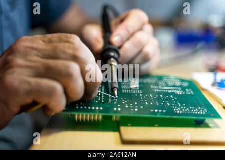 Senior man working on electronic circuits in his workshop, close up Stock Photo