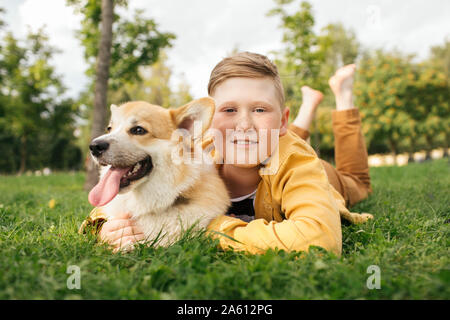 Boy with Welsh Corgi Pembroke in a park Stock Photo