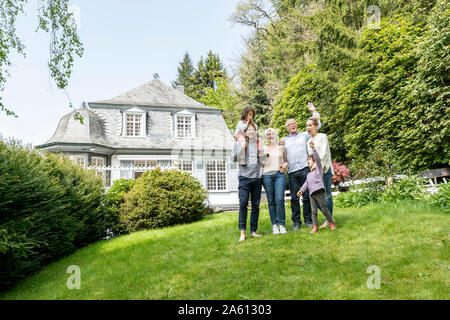 Happy extended family standing in garden of their home Stock Photo