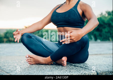 Woman practicing yoga in the rain Stock Photo