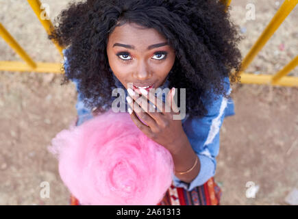 Portrait of young woman with pink candyfloss Stock Photo