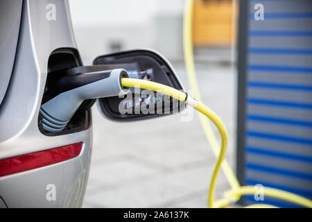 Electric car gettig charged at an charging station Stock Photo