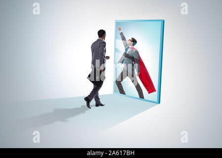 The businessman seeing himself in mirror as superhero Stock Photo - Alamy