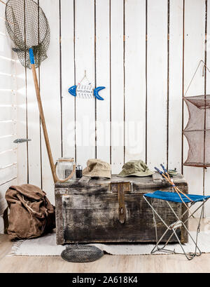 big old chest with things for fishing in decorated retro wooden room Stock Photo