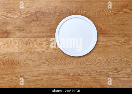 Empty white plate on textured wooden table Stock Photo