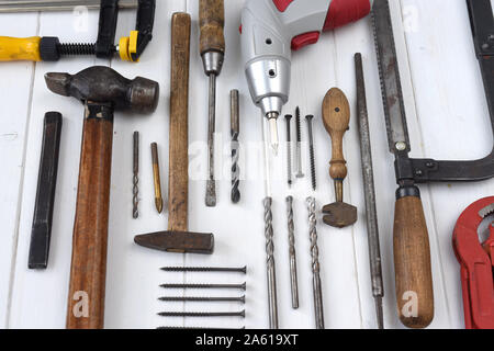 different carpenters and mechanics tools on a white wooden table Stock Photo
