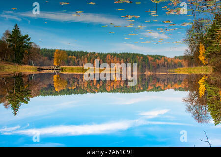 Reflections of Autumn. Beautiful Autumn landscape with lake and calm water, forest with yellow, orange and green trees, October, November background Stock Photo