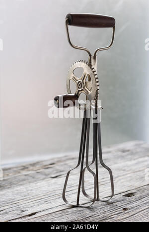 https://l450v.alamy.com/450v/2a61d4y/vintage-manual-whisk-eggs-beater-stand-on-the-the-rustic-wooden-table-vertical-with-copy-space-2a61d4y.jpg