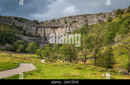 Malham Cove is a limestone formation in Yorkshire Dales National Park, England. It was formed by a waterfall carrying meltwater from glaciers at the e Stock Photo