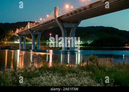 A tranquil night view of the illuminated bridge spanning the Namhan River in Chungju, South Korea. Stock Photo