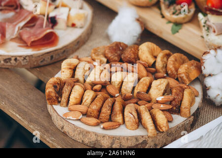 Dried figs and almonds on a wooden plate. Healthy snacks. Stock Photo