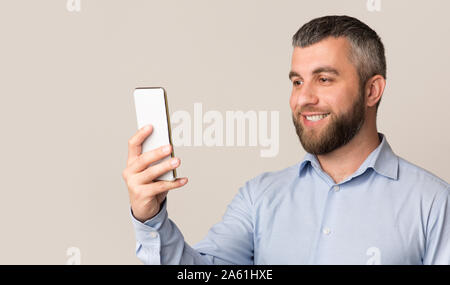 Cheerful man using facial recognition on modern smartphone Stock Photo