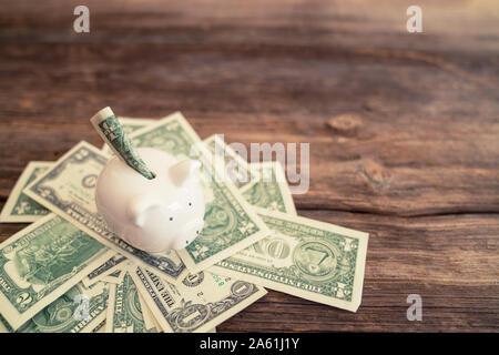 Saving money in piggy-bank, a metophor to financial busness and economy. Stock Photo