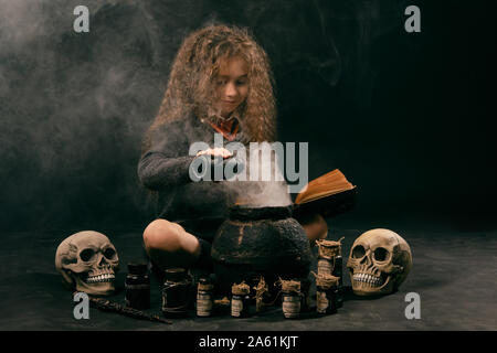 Portrait of a nice enchantress child with magnificent long brown hair dressed in a navy blue jumper, gray skirt, knee socks and shoes. She is sitting Stock Photo