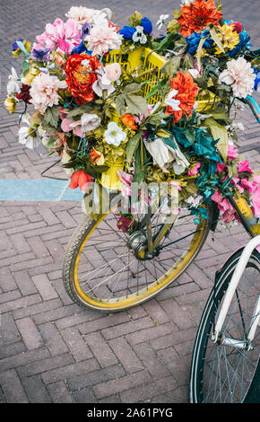 Bike covered in flowers on a street in Amsterdam, the Netherlands Stock Photo