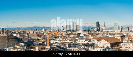 Milan skyline. Large panoramic view of Milano city, Italy. The mountain range of the Lombardy Alps in the background. Italian landscape. Stock Photo
