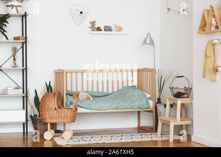 Baby Bedroom Interior with Cozy Wooden Bed And Wicker Stroller Stock Photo