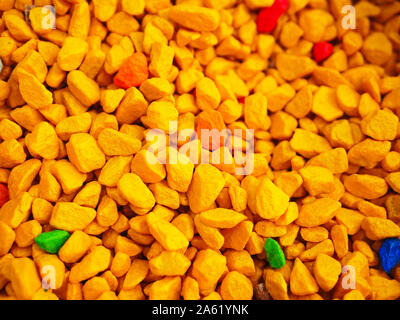 orange little pebbles. Background composed of small orange pebbles. With many possible uses. Texture composed of tiny pebbles in orange shade  Stock Photo