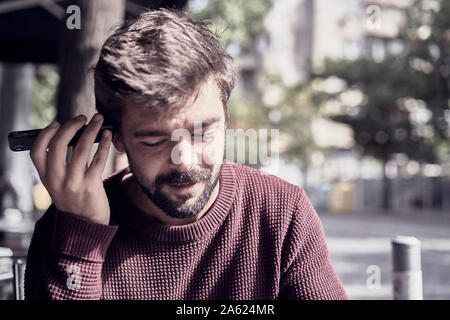 Attractive young bearded man using his smartphone in the cafe Stock Photo