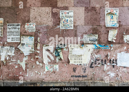Yerevan, Armenia. August 17, 2018. Flyers posted on a stone wall. Stock Photo