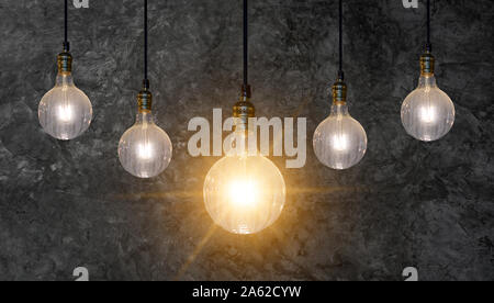 different Light bulb idea Many bulbs are arranged in a row and one of them is illuminated. Concept idea Stock Photo