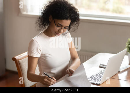 Concentrated young african american business woman signing documents, medical insurance. Stock Photo