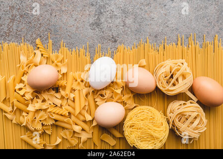 Different types of pasta that we use every day in the kitchen when cooking. View from above. Products flat-lying. Place for a description or text. Stock Photo
