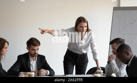 Angry caucasian female boss firing sad stressed african male worker Stock Photo