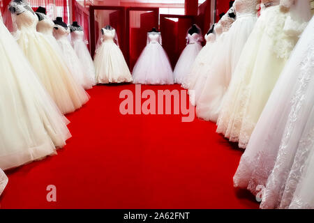 Collection of wedding dresses in the shop. Wedding dresses in a shop. Beautiful wedding dresses on a mannequins. Stock Photo