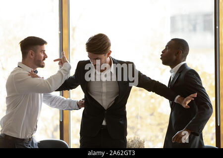 Male colleague set apart angry diverse businessmen fighting in office Stock Photo