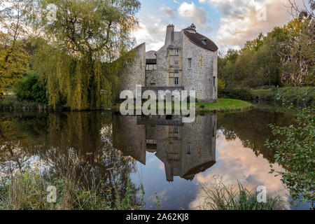 MONTMORENCY, FRANCE - NOVEMBER 10, 2013: The hunting Castle ('Château de la chasse') reflecting on a pond at sunset, located in the Montmorency Forest. Stock Photo