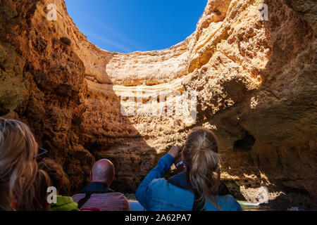 tourists enjoying boat tour of sea caves on algarve coast portugal Stock Photo