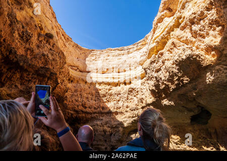 tourists enjoying boat tour of sea caves on algarve coast portugal Stock Photo