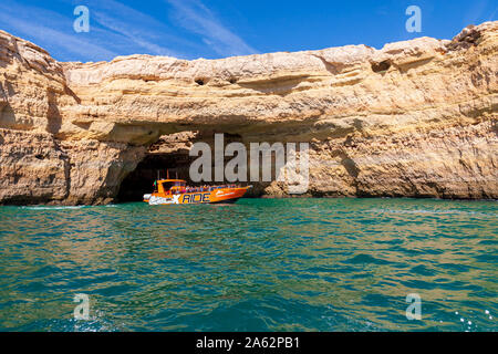 tourists enjoying boat tour of sea caves on algarve coast portugal Stock Photo