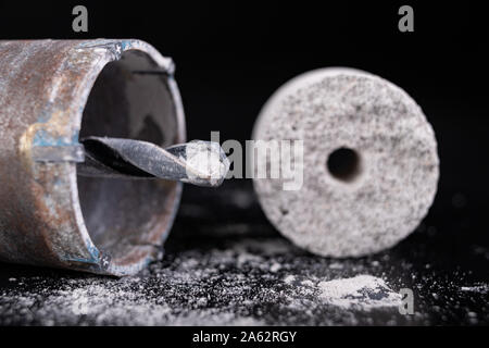 Steel large drill for drilling holes in concrete. Hole saw used to make holes for electrical boxes. Dark background. Stock Photo
