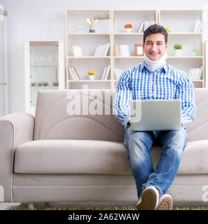 The man freelancer in a cervical collar neck brace working from home Stock Photo