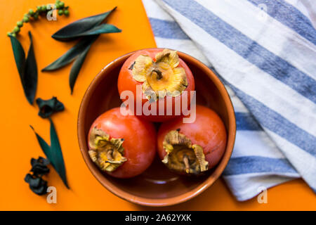 Still life with persimmon on colorful background Stock Photo