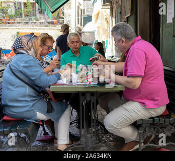 Montenegro, Sep 21 2019: Two couples of tourists having a meal at one of the outdoor taverns in Kotor Old Town Stock Photo