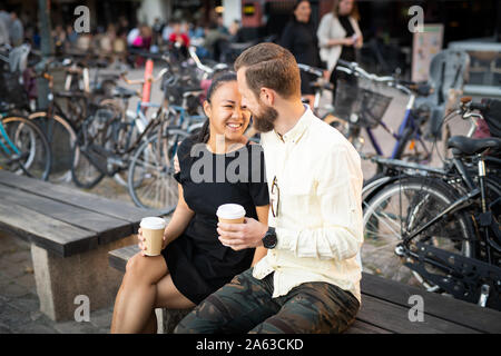 Interracial couple on outdoor bench Stock Photo