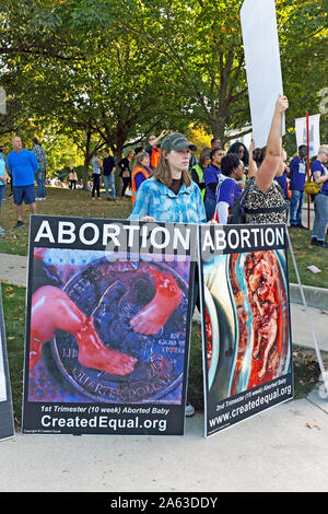 Anti-abortion demonstrators hold controversial signs during a political rally on Otterbein University campus in Westerville, Ohio, USA.