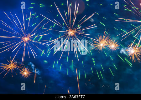Inexpensive fireworks over the city red, green and yellow on the blue sky. Bright and shiny. For any purpose. Celebration concept.