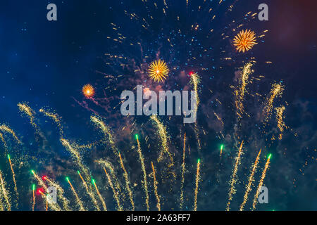 Inexpensive fireworks over the city sky, red, green and white with colour sparks. Bright and shiny. For any purpose. Celebration concept.