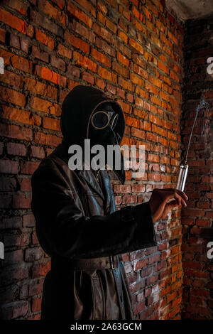 Terrible plague doctor with syringe. Halloween concept. Stock Photo