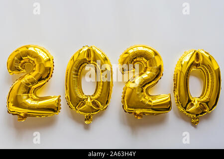 Foil balloons golden color in the form of numbers 2020. New year celebration, christmas, xmas. Flat lay with Air Balloons, top view, mockup, overhead Stock Photo