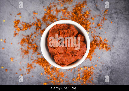 curry paste cayenne pepper and dried chilli peppers background / group of red hot chilli powder on black plate top view ingredients table asian food s Stock Photo