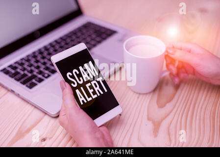 Handwriting text Scam Alert. Conceptual photo unsolicited email that claims the prospect of a bargain woman laptop computer smartphone mug office supp Stock Photo