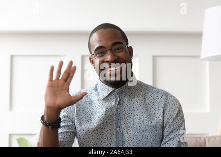 Smiling black man waving talking on video call Stock Photo