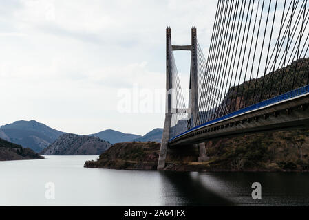 Modern suspension bridge across reservoir Los Barrios de Luna in Castile and Leon, Spain. Stock Photo