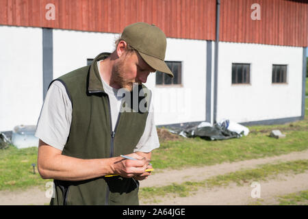 man taking notes while tending to his garden Stock Photo